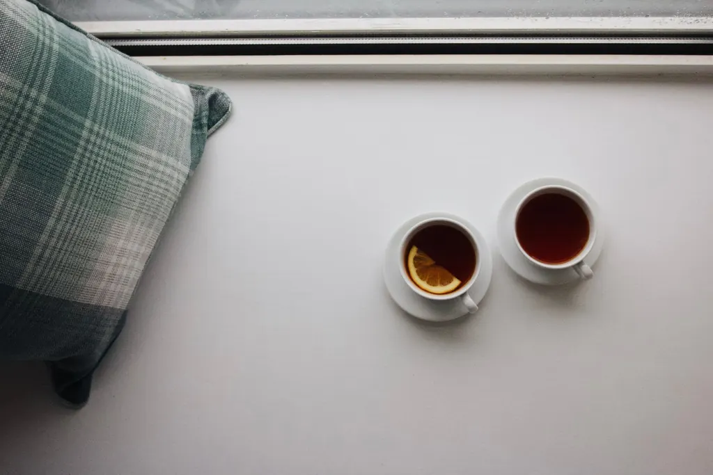 Two cups of tea on a windowsill, ready for a quiet conversation