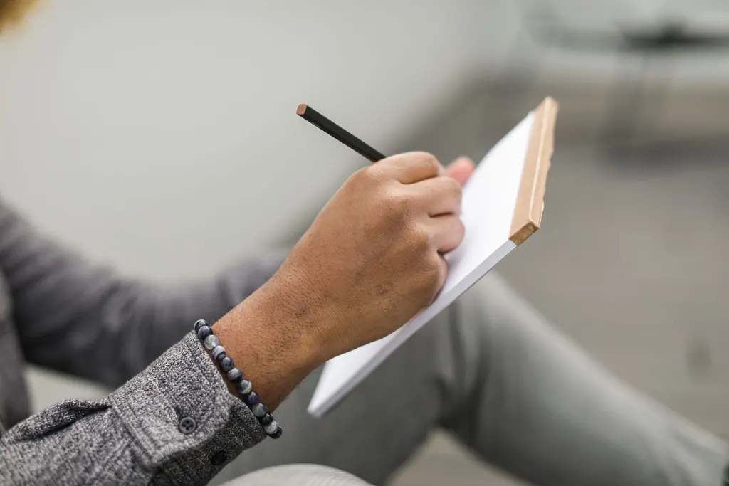 A person writing thoughts down in a notebook